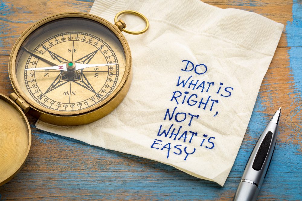 Do what is right, not what is easy advice or reminder - handwriting on a napkin with an antique brass compass, metaphor for core values